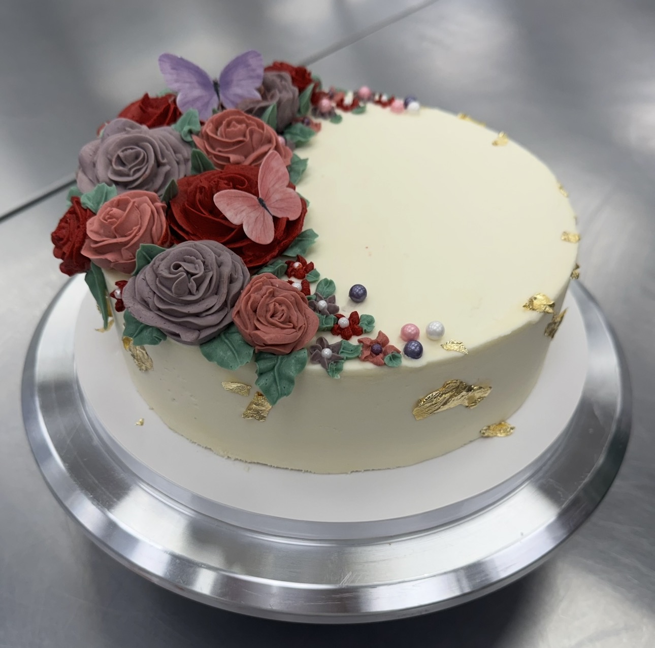 Elegant white cake decorated with fresh floral arrangements on a white stand