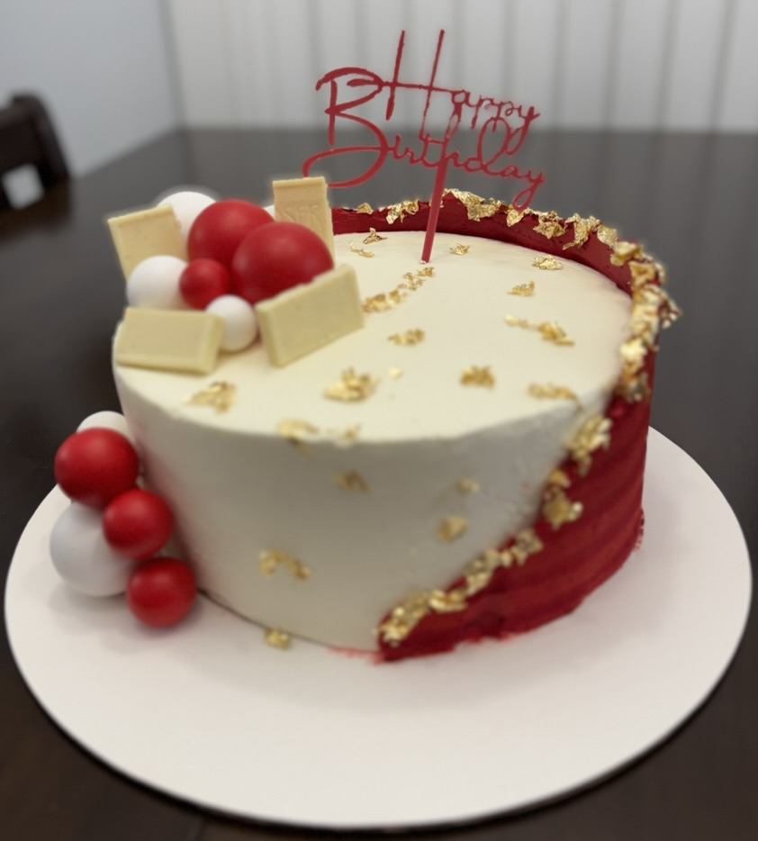 Elegant birthday cake showing full top and sides with decorative details